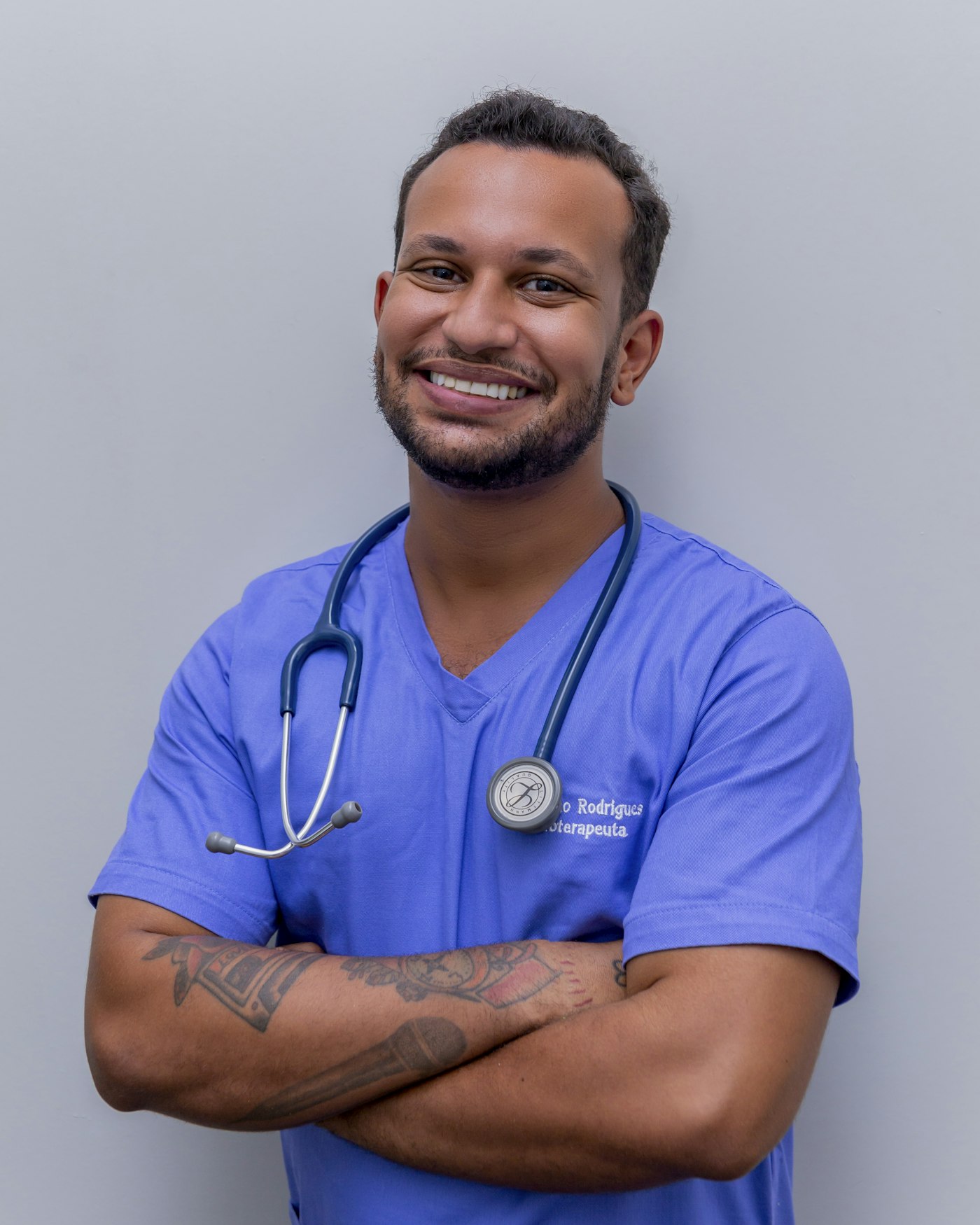 Fisioterapeuta sorridente de braços cruzados